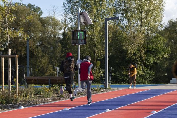 Deux coureurs sur la piste d'athlétisme à Saint-Dizier, avec un radar pédagogique EVOLIS Vision affichant une vitesse de 17 km/h