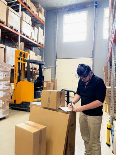 A logistics technician arranging the reshipment of an educational radar after it has been repaired.